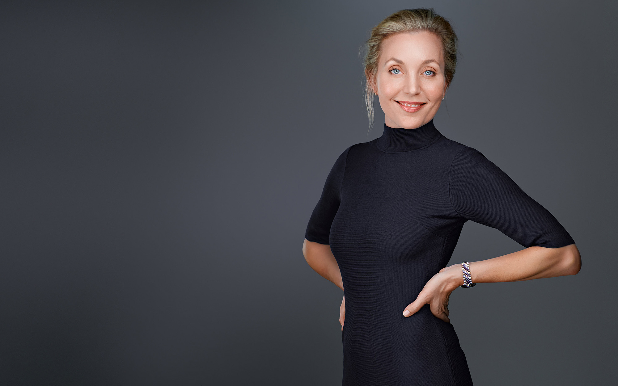 Professional Studio Headshot — Palo Alto Studio headshot of a woman in a black dress, smiling, on a gray background.