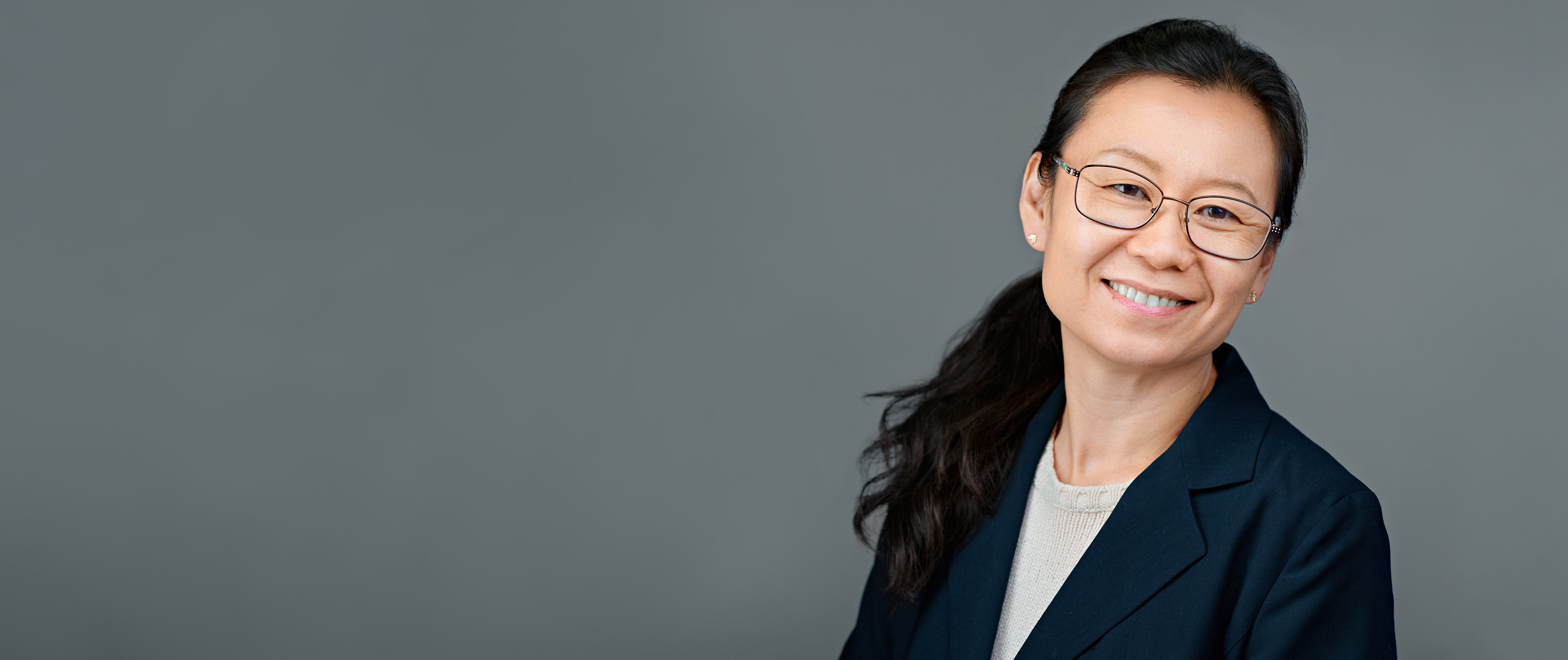 Headshot of a confident professional woman smiling with ease—captured to reflect reliability, polish, and the quiet support that makes complex tasks feel effortless.