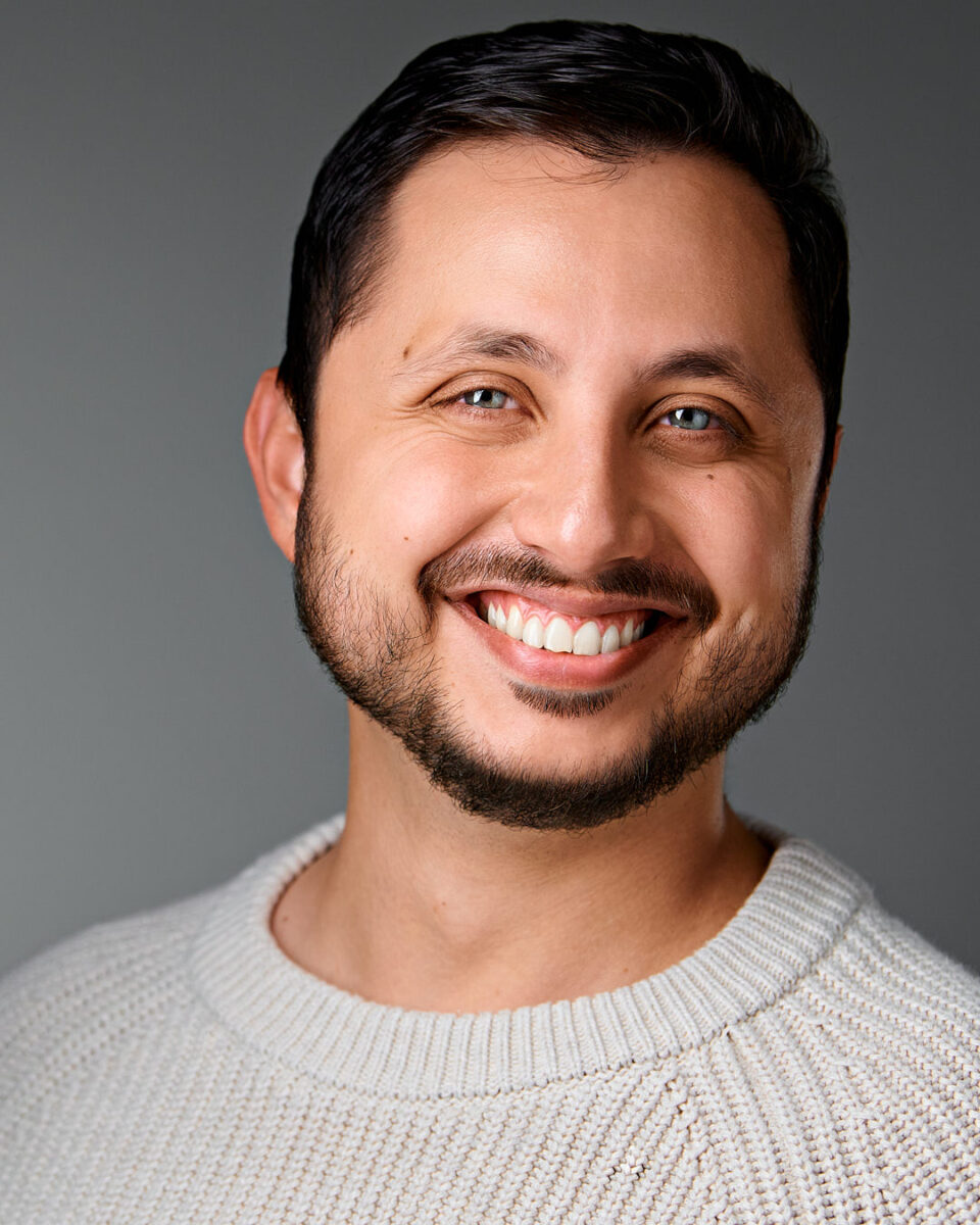 Smiling man in a light sweater, captured by Dean Birinyi in Palo Alto for company headshots in Silicon Valley.