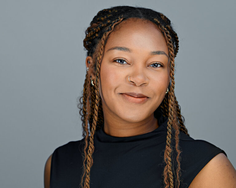 Smiling professional woman in a black turtleneck, captured in a studio by Dean Birinyi for a Palo Alto company headshot session.