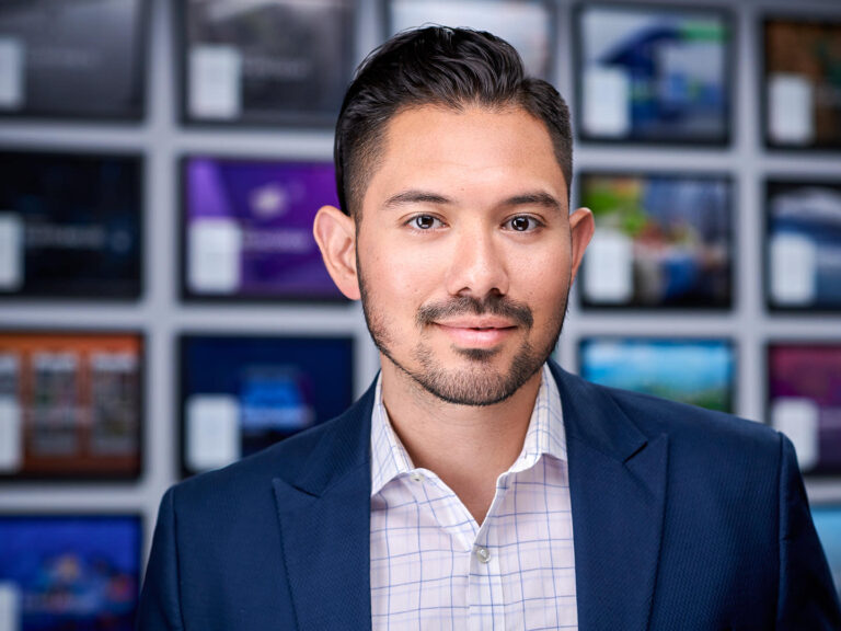 Business professional in navy blazer and checked shirt, photographed by Dean Birinyi for company headshots in Palo Alto.