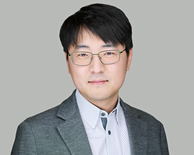 Business professional in gray blazer and patterned shirt, photographed by Dean Birinyi for company headshots in Palo Alto.