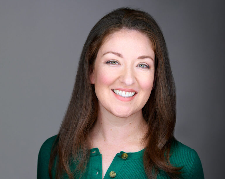 Smiling woman in a green top, professionally photographed by Dean Birinyi in Palo Alto for company headshots in Silicon Valley.