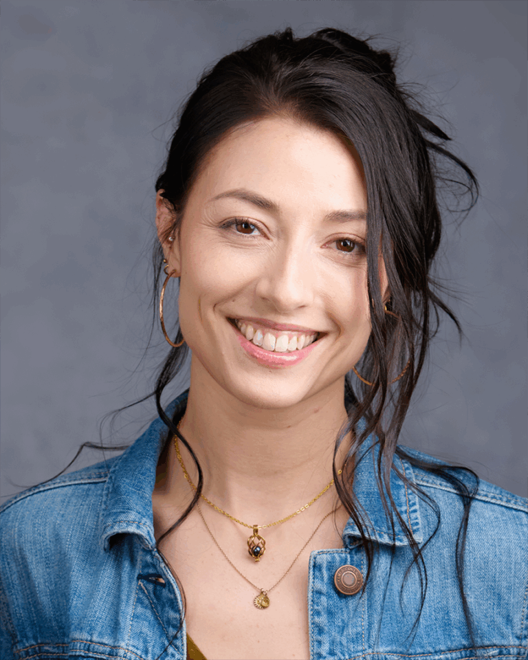 Confident female professional with short hair and a direct gaze, wearing a dark blazer over a white top. Photographed against a soft gray background in a Palo Alto studio.