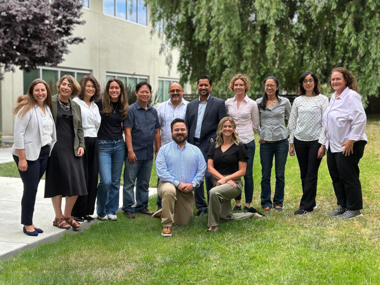 Thirteen Redwood City team members outdoors, captured during a company headshot and portrait session by Dean Birinyi.