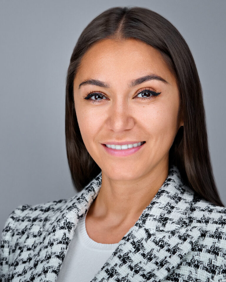 Professional headshot of a Redwood City team member in a black-and-white jacket, photographed in-studio by Dean Birinyi