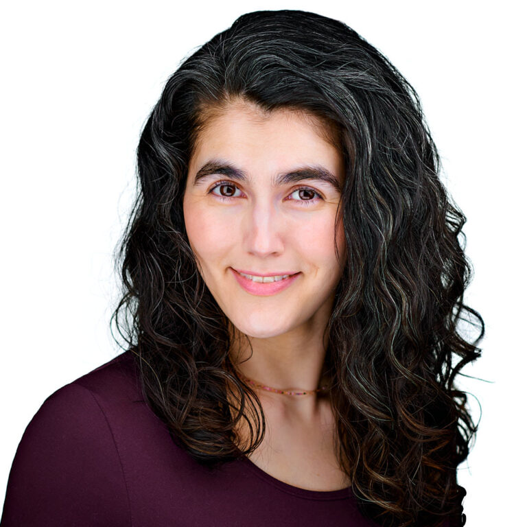 Professional headshot of a woman with dark curly hair wearing a burgundy blouse, photographed by Dean Birinyi in Palo Alto.