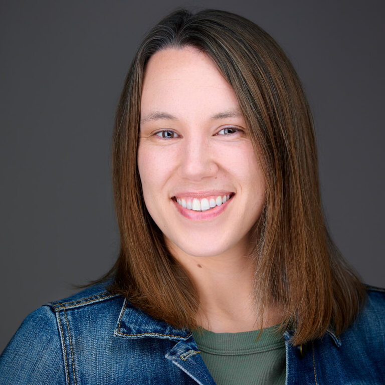 Professional headshot of a smiling woman in a denim jacket and green top, photographed by Dean Birinyi in Mountain View.