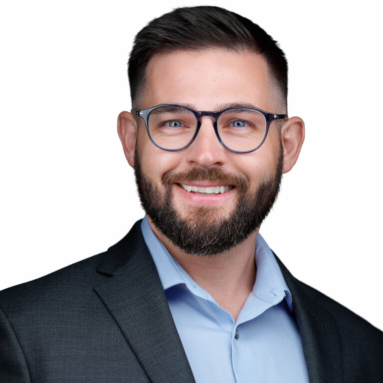 Professional headshot of a smiling man with beard and glasses wearing a suit jacket, photographed by Dean Birinyi in Sunnyvale.