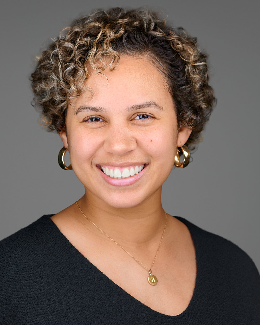Polished professional headshot photographed in Palo Alto with clean studio lighting and a neutral gray background, showing the consistent look used for new-hire headshots across Silicon Valley companies.