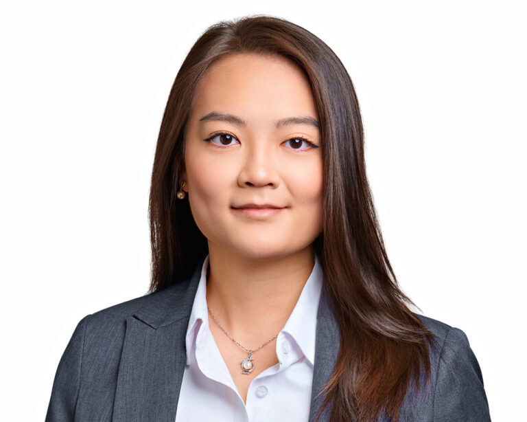 Professional headshot of a woman wearing a gray blazer, photographed on a white background with refined studio lighting in Palo Alto.