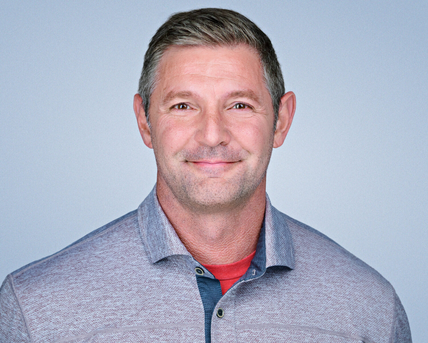 Professional headshot of a smiling man photographed in Palo Alto with soft studio lighting and a clean light-gray background.