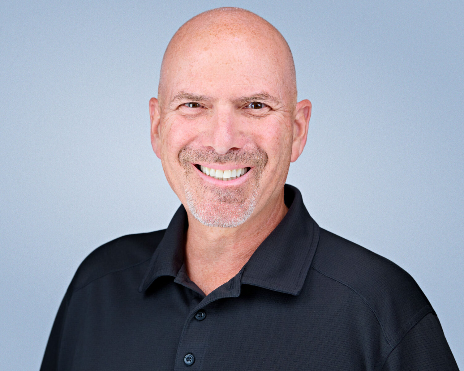 Professional headshot of a smiling man photographed in Palo Alto with soft studio lighting and a clean light-gray background.