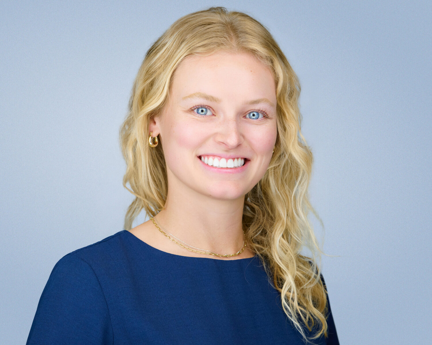 Professional headshot of a smiling woman photographed in Palo Alto with soft studio lighting and a clean light-gray background.