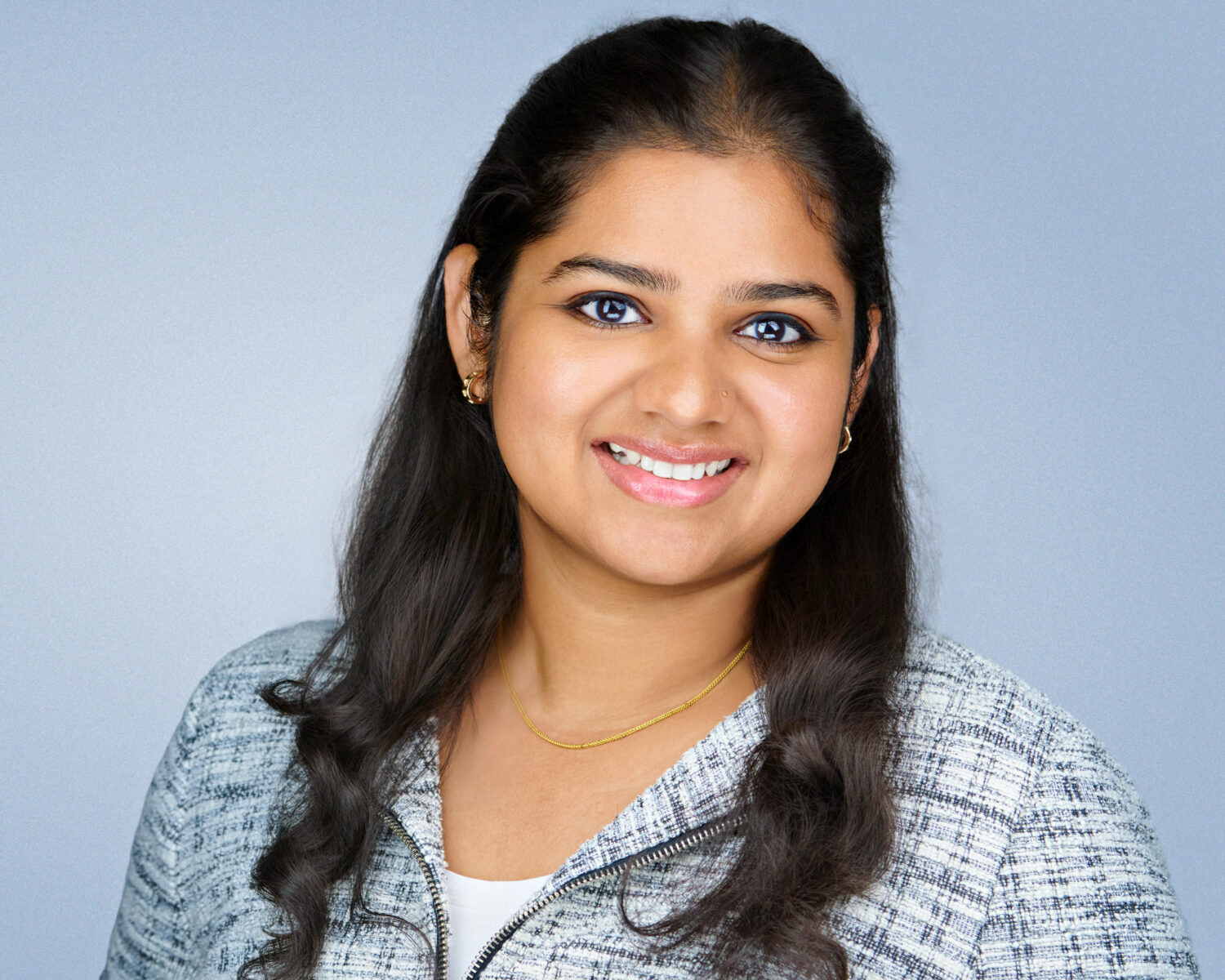 Professional headshot of a smiling woman photographed in Silicon Valley with soft studio lighting and a clean light-gray background.