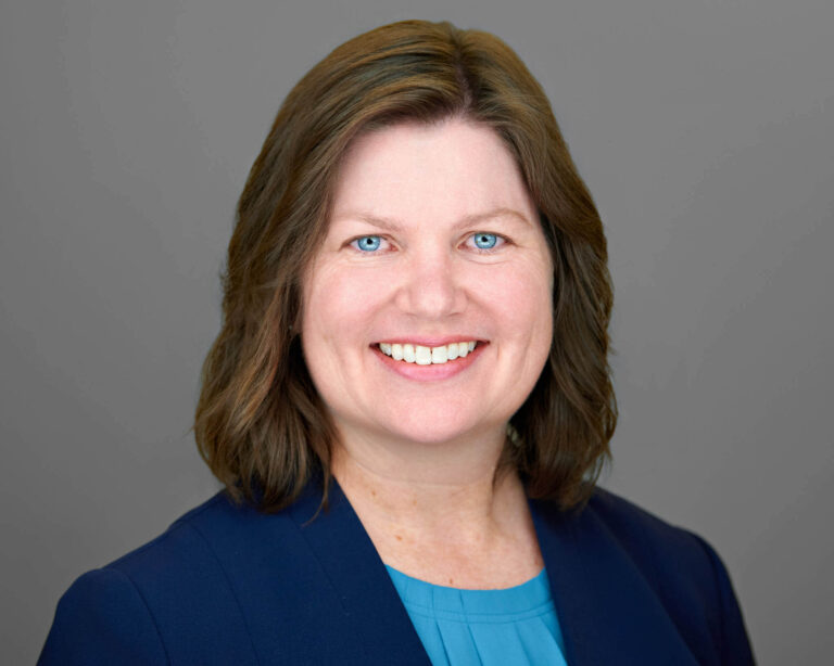 Professional corporate headshot of a South San Francisco employee on a neutral gray background