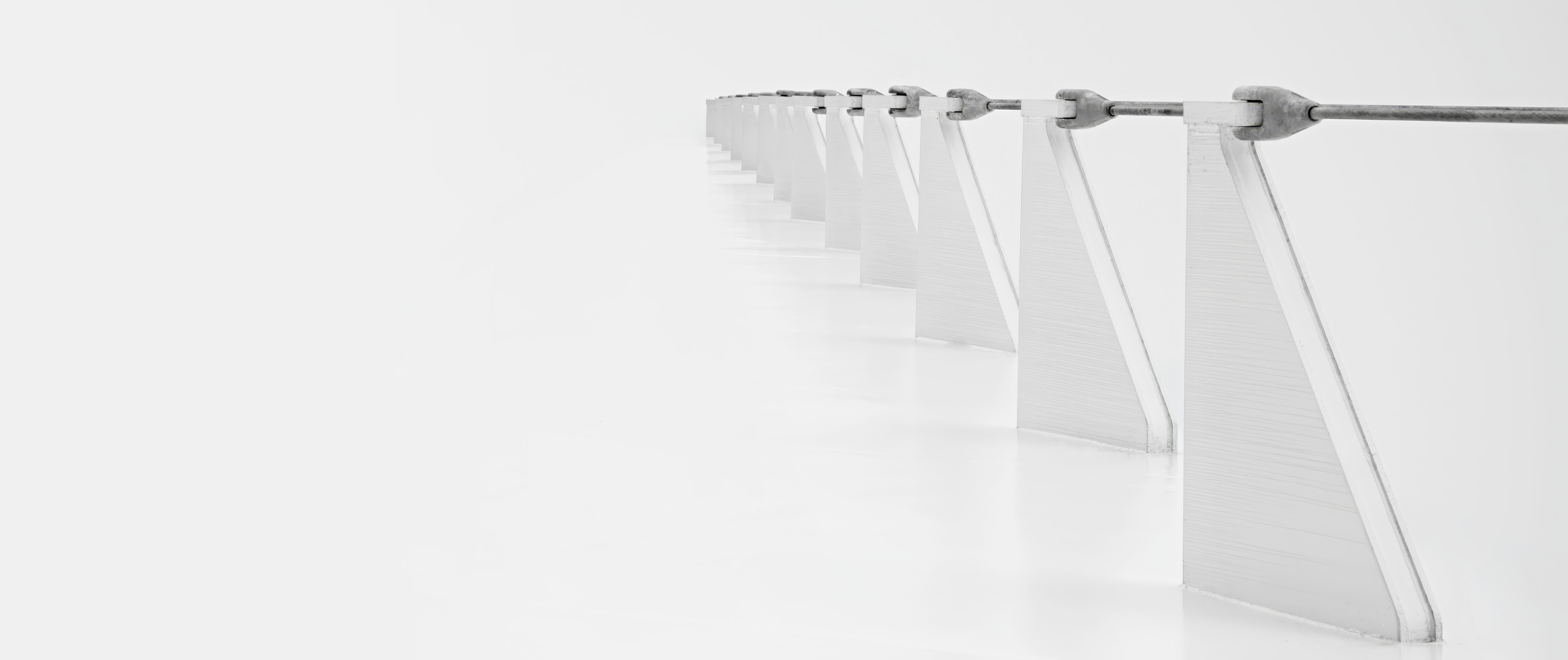 Black-and-white abstract detail of the Sundial Bridge with repeated white supports held by a steel cable.