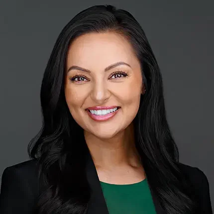 Professional headshot of a confident woman in a green top and black blazer, photographed by Dean Birinyi in Palo Alto.