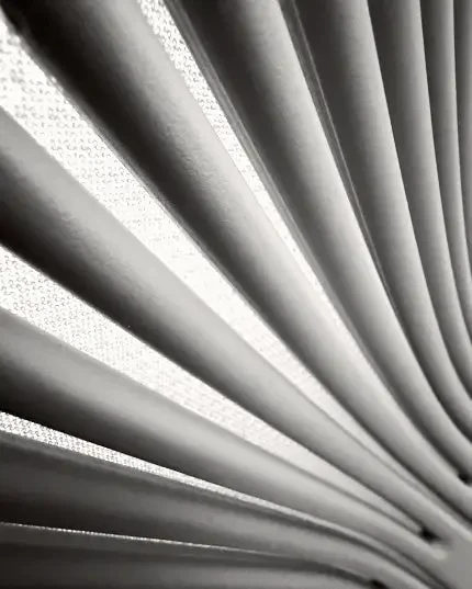 Black-and-white close-up of repeating curved ribs radiating diagonally across the frame.