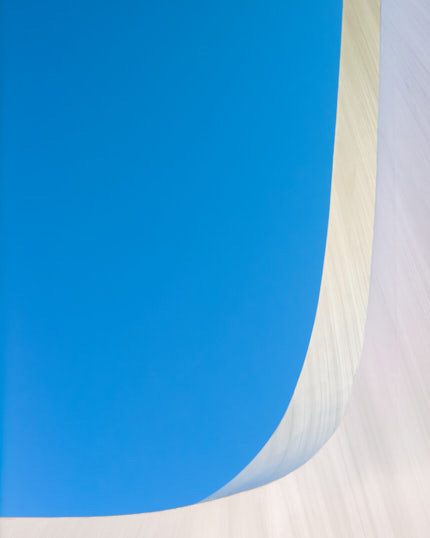 Abstract photograph of the Sundial Bridge with a sweeping white curve against a vivid blue sky.